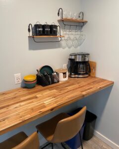 Guest coffee bar amenity at The Homestead Palisade with wooden countertop, coffee maker, tea and sugar canisters, and bar stools